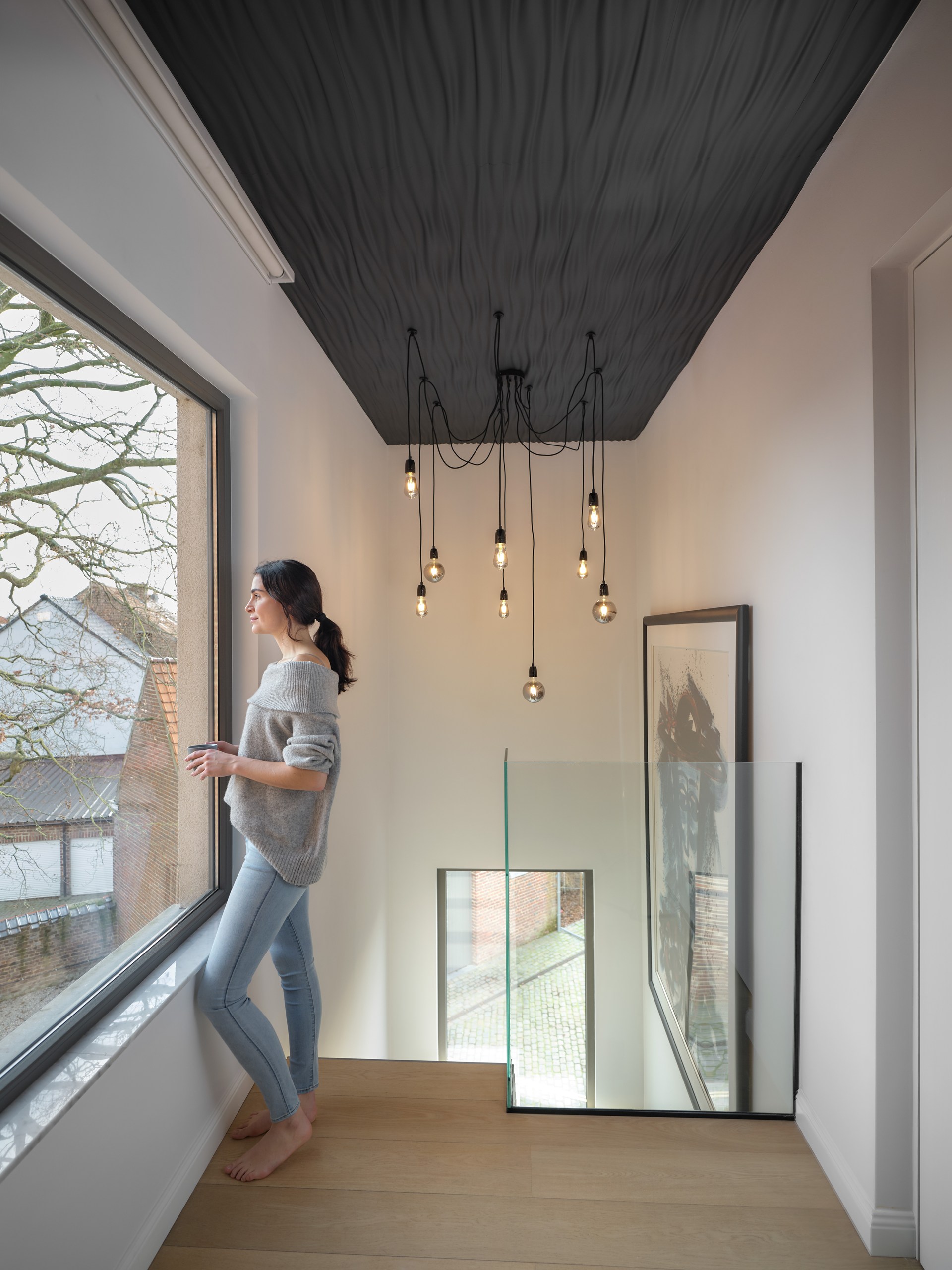 Texturierte Wandpaneele an der Decke sorgen für eine skulpturale Deckenkonstruktion mit starker optischer Tiefe.