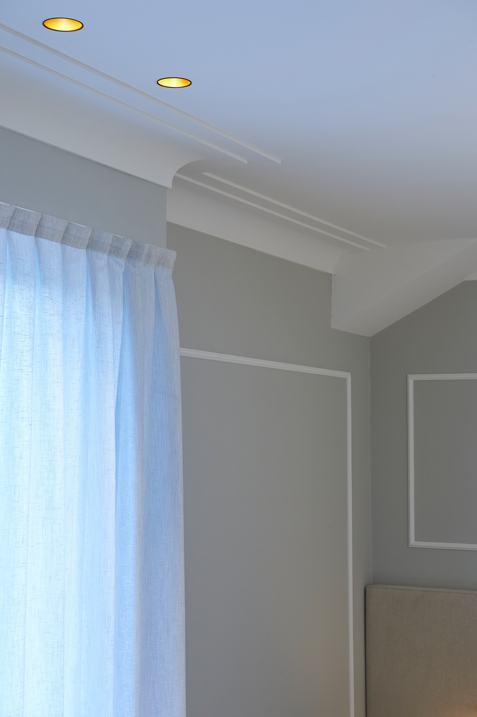 Minimalistische Deckenleisten definieren den Übergang zwischen Wand und Decke in einem modernen Interieur.